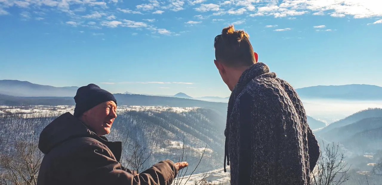 Zwei Männer blicken über ein verschneites Tal