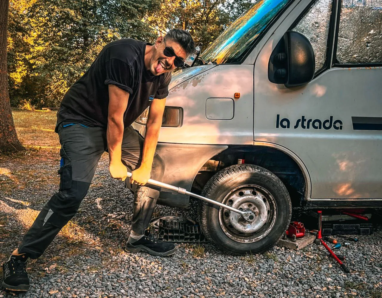 Arbeit am Rad des Vans mit Werkzeug